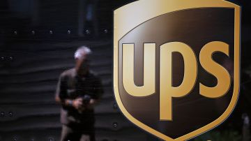 In this June 20, 2014 photo, the United Parcel Service logo is seen on the side of a truck as driver Marty Thompson is reflected returning from a delivery in Cumming, Ga. (AP Photo/David Goldman)