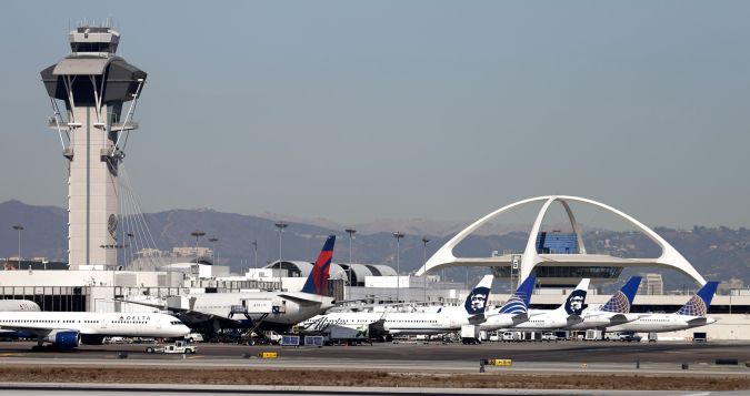 Airplanes sit on the tarmac at Los Angeles International Airport Friday, Nov. 1, 2013. Thousands of fliers were delayed Friday after a shooting in Terminal 3 closed parts of the airport for hours, prompting authorities to evacuate a terminal and stop flights headed for the city from taking off from other airports. Los Angeles police said a suspected gunman has been taken into custody. (AP Photo/Gregory Bull)