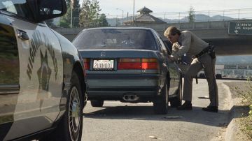 California Highway Patrol officer Rob Lund gives Virginia Luk of Temple City, Calif., a warning for exceeding the speed limit on Interstate 210 in Altadena, California on Sunday, Dec. 17, 1995. Lund says that the CHP will be strictly enforcing the new speed limits. (AP Photo/Mark J. Terrill)