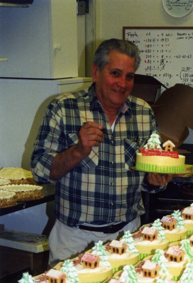 Raúl Porto posa junto a una dotación de pasteles recién horneados en el restaurante original de Porto's en Glendale durante los años 90.