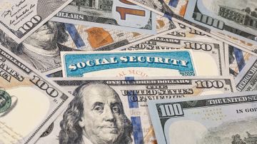 Tarjeta de seguridad social entre billetes de Estados Unidos.