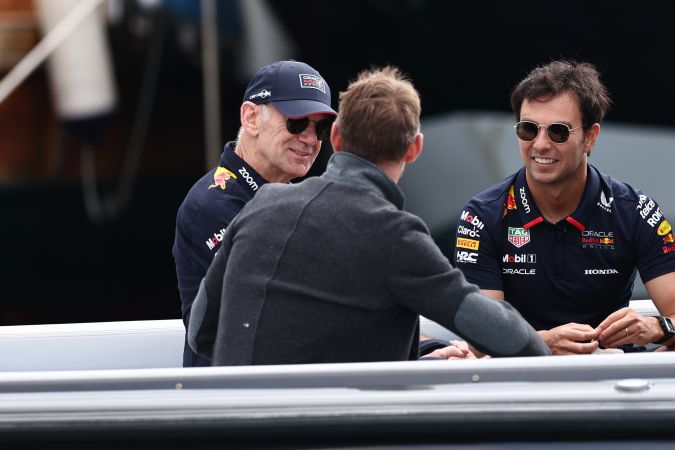 El mexicano Sergio "Checo" Pérez conversando con el ingeniero jefe de Red Bull, Adrian Newey y el ex piloto de F1 británico Jenson Button.