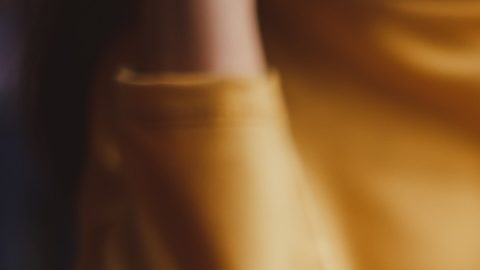 Mano de mujer poniendo moneda de en alcancía.