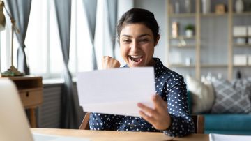 Mujer feliz revisando el monto de su devolución de impuestos.