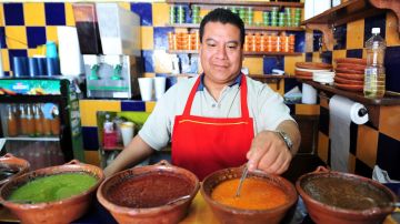 Trabajador mexicano preparando salsa en un restaurante.