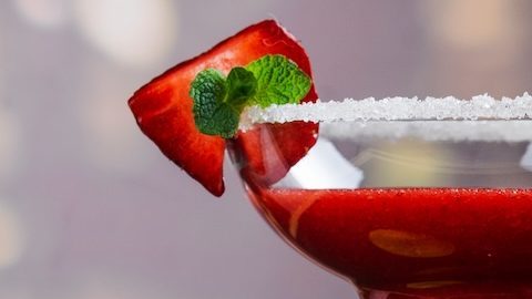 Mojito de fresa, nachos de maíz y tragos de tequila con limón sobre mesa de madera Fondo de celebración del Cinco de Mayo.
