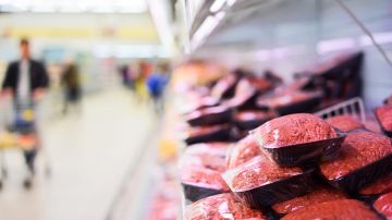 Carne molida fresca envasada en el estante del supermercado.