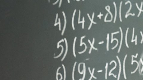 Niños felices y diversos, estudiantes multiculturales de secundaria abrazando a una maestra apreciando y agradeciendo a la educadora en el aula