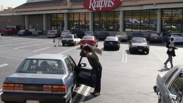 A locked-out Ralphs grocery store clerk talks to customers in their car about their decision to shop at the store in Los Angeles Thursday, Oct. 23, 2003, in Los Angeles. As the grocery strike rolled through its second week with no new negotiations planned in Southern and Central California, shopper fatigue began to set in for many who said they were frustrated by the lack of progress in contract talks and tired of running around town for their groceries. (AP Photo/Nam Y. Huh)