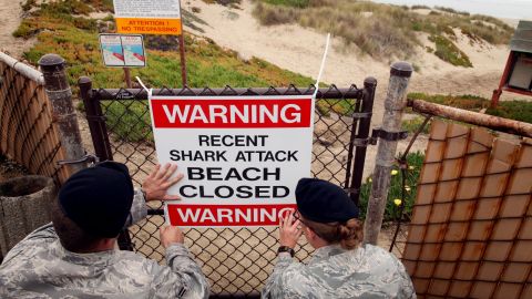 Airmen 1st class Daniel Clark, left, and Staff Sgt. Keri Embry, post a sign warning surfers of a recent shark attack Friday, Oct. 22, 2010, at Vandenburg Air Force Base, Calif. Lucas Ransom, 19, was boogie-boarding in the surf line about 100 yards off of Surf Beach with a friend when a shark suddenly pulled him under the water shortly before 9 a.m., according to a statement from the Santa Barbara County Sheriff's Department. Surf Beach, 130 miles northwest of Los Angeles, is on the property of Vandenberg Air Force Base but is open to the public. (AP Photo/Spencer Weiner)