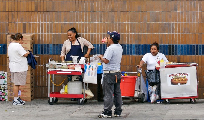 FILE - This Aug. 3, 2006 file photo shows street vendors in the Echo Park section of Los Angeles. Two members of the Los Angeles City Council want to legalize sidewalk vendors, arguing it will help people who fear deportation in the wake of President-elect Donald Trump's promise to ship out millions who are in the country illegally. Joe Buscaino and Curren Price sent a letter Tuesday, Nov. 22, 2016, to their fellow council members outlining a policy to decriminalize and regulate street vending. (AP Photo/Damian Dovarganes, File)