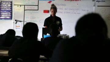 In this Friday, July 13, 2018 photo, teacher Zara Gibbon darkens the room to inspire students to write an essay that begins, "One dark and stormy night..." at Animo Westside Charter Middle School during a summer session to introduce new students to the school they will attend in the fall, in the Playa Del Rey area of Los Angeles. Animo is one of many schools to benefit from donations by billionaires that are influencing state education policy by giving money to state-level charter support organizations to sustain, defend and expand the charter schools movement across the country. (AP Photo/Reed Saxon)