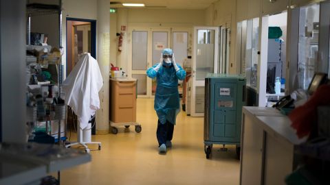 A healthcare worker wearing protective equipment walks through the intensive care unit at the Joseph Imbert Hospital Center in Arles, southern France, Wednesday, Oct. 28, 2020. Many French doctors are urging a new nationwide lockdown, noting that 58% of the country's intensive care units are now occupied by COVID patients and medical staff are under increasing strain. (AP Photo/Daniel Cole)