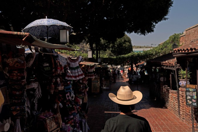 FILE - In this June 4, 2021, file photo, a shopper walks along Olvera Street in Los Angeles. Latinos in the U.S. were hard hit by the pandemic both financially and personally, but many feel generally optimistic that the worst is behind them, according to a new study by the Pew Research Center. (AP Photo/Jae C. Hong, File)