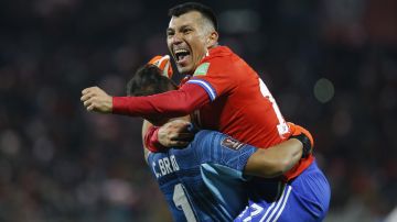 Chile's Gary Medel, top, celebrates with his teammates Claudio Bravo after teammate Benjamin Brereton scored his side's third goal against Venezuela during a qualifying soccer match for the FIFA World Cup Qatar 2022 at San Carlos de Apoquindo stadium in Santiago, Chile, Thursday, Oct. 14, 2021. (Claudio Reyes/Pool via AP)