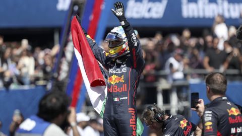 Mexican Formula One Red Bull driver Sergio "Checo" Perez waves at fans while holding a Mexican national flag after an exhibition race through the streets of Guadalajara, Mexico, Tuesday, Oct. 25, 2022. Perez will compete in the upcoming Mexico Grand Prix in Mexico City. (AP Photo)