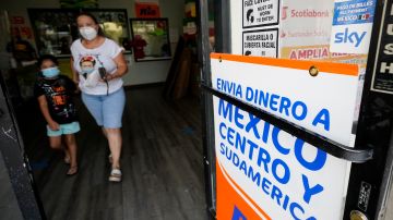Una mujer sale de una tienda que ofrece servicios para enviar remesas a México y Centroamérica, en San Diego, California.