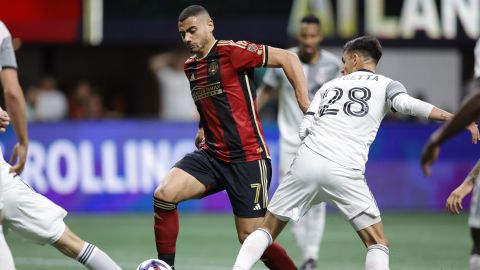 Atlanta United forward Giorgos Giakoumakis, left, drives past Toronto FC defender Raoul Petretta, right during the second half of an MLS soccer match, Saturday, March 4, 2023, in Atlanta. (AP Photo/Alex Slitz)