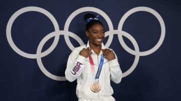FILE - Simone Biles, of the United States, poses wearing her bronze medal from balance beam competition during artistic gymnastics at the 2020 Summer Olympics, Tuesday, Aug. 3, 2021, in Tokyo, Japan. The sport of gymnastics' international investigations agency was created in 2019 to help protect athletes after the American sexual abuse scandal. The Gymnastics Ethics Foundation has now published its strategy to set new standards in safeguarding before the 2028 Los Angeles Olympics. The “Gymnasts 2028” details goals for its work to protect athletes from harassment and abuse, investigate complaints, prosecute disciplinary cases and monitor national federations. (AP Photo/Natacha Pisarenko,File)