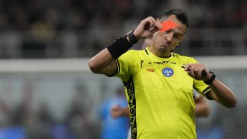 Referee Maurizio Mariani reacts after showing red card to AC Milan's Malick Thiaw during a Serie A soccer match between AC Milan and Juventus, at the San Siro stadium in Milan, Italy, Sunday, Oct. 22, 2023. (AP Photo/Luca Bruno)