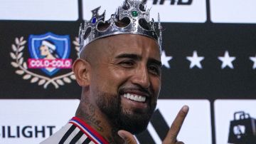 Chilean soccer player Arturo Vidal wears a crown because his nickname is "King" as he is presented as a new player with Colo Colo during a press conference at Monumental stadium in Santiago, Chile, Tuesday, Jan 23, 2024. Vidal returns to Colo Colo after 17 years of a successful career in soccers clubs in Europe and South America. (AP Photo/Esteban Felix)