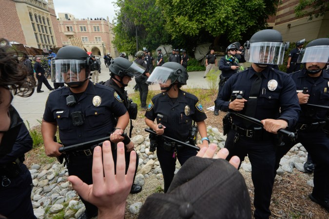Police officers block pro-Palestinian protesters on the campus of UCLA in Los Angeles, Thursday, May 23, 2024. (AP Photo/Damian Dovarganes)