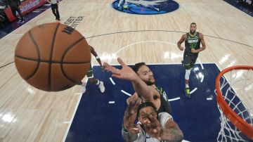 Dallas Mavericks forward Derrick Jones Jr., bottom, and Minnesota Timberwolves forward Kyle Anderson reach for a rebound during the first half of Game 5 of the NBA basketball Western Conference finals Thursday, May 30, 2024, in Minneapolis. (AP Photo/Abbie Parr)