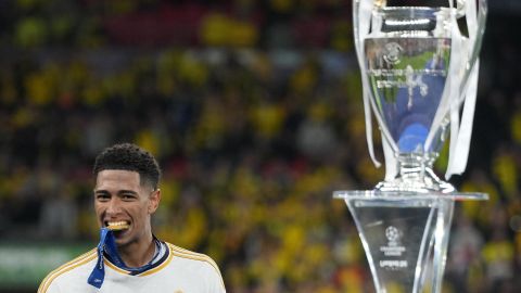 Real Madrid's Jude Bellingham bites his medal walking by the trophy after winning the Champions League final soccer match between Borussia Dortmund and Real Madrid at Wembley stadium in London, Saturday, June 1, 2024. (AP Photo/Kirsty Wigglesworth)