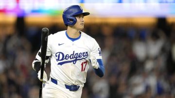 Los Angeles Dodgers' Shohei Ohtani drops his bat after hitting a two-run home run during the sixth inning of a baseball game against the Texas Rangers Tuesday, June 11, 2024, in Los Angeles. (AP Photo/Mark J. Terrill)