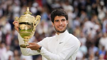 FILE - Spain's Carlos Alcaraz celebrates with the trophy after beating Serbia's Novak Djokovic to win the final of the men's singles on day fourteen of the Wimbledon tennis championships in London, Sunday, July 16, 2023. Wimbledon's total prize money fund will rise to a record 50 million pounds (about $64 million), with the singles champions each earning 2.7 million pounds ($3.45 million), All England Club officials announced Thursday, June 13, 2024. (AP Photo/Kirsty Wigglesworth, File)