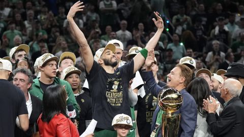 Boston Celtics forward Jayson Tatum, center, celebrates with to Celtics co-owner Stephen Pagliuca, center right, near the Larry O'Brien Championship Trophy after the Celtics won the NBA championship with a Game 5 victory over the Dallas Mavericks on Monday, June 17, 2024, in Boston. (AP Photo/Charles Krupa)