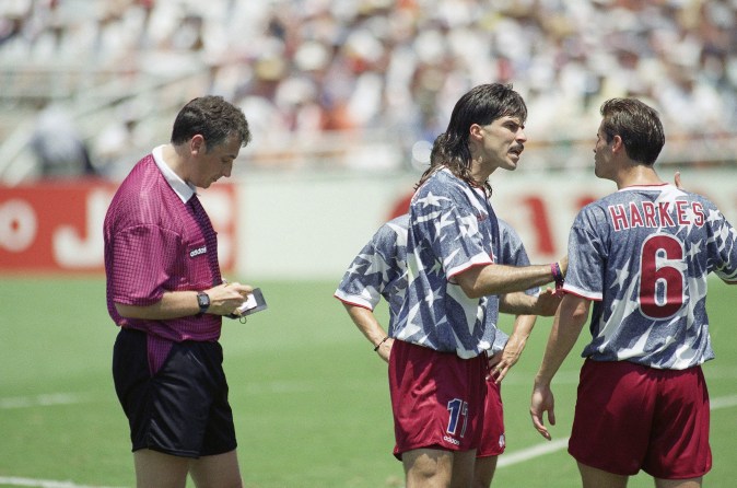 United States? players Marcelo Balboa, center, and John Harkes, right, argue after Dutch referee Mario Van Der Ende, left, yellow-carded Harkes during the World Cup soccer championship Group A first-round match against Romania at the Rose Bowl, on Sunday, June 26, 1994 in Pasadena, Calif. Romania defeated the United States 1-0. (AP Photo/Douglas C. Pizac)