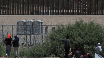 Agentes de la Guardia Nacional de Texas dialogan con altavoces con los inmigrantes, en el muro que divide la frontera, frente a Ciudad Juárez