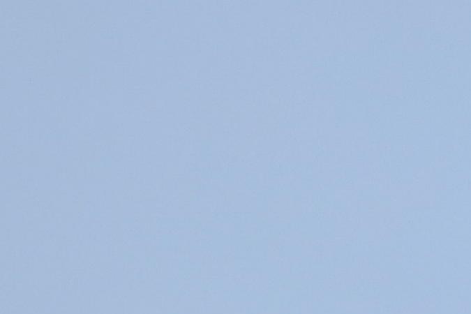 Personas caminando por los alrededores de la Torre Eiffel adornada con los anillos olímpicos cuando faltan menos de dos meses para el inicio de París 2024.