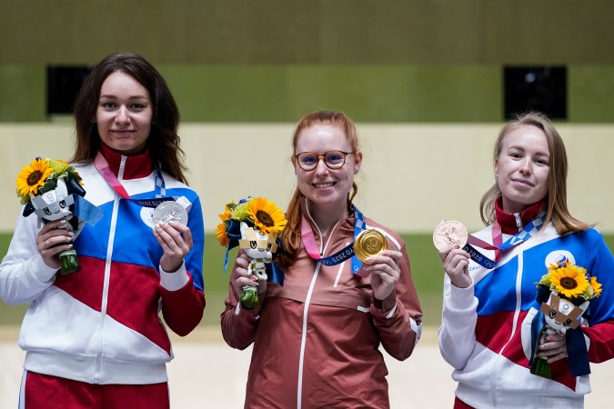 La suiza Nina Christen, en el centro, posando en lo más alto del podio de la prueba de tiro deportivo de Tokio 2020 donde ganó la medalla de oro.