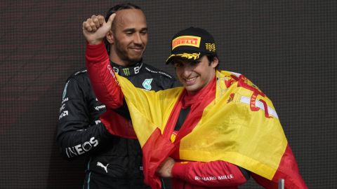 Ferrari driver Carlos Sainz of Spain celebrates after winning the British Formula One Grand Prix as Mercedes driver Lewis Hamilton of Britain, rear, looks on, at the Silverstone circuit, in Silverstone, England, Sunday, July 3, 2022. (AP Photo/Matt Dunham)