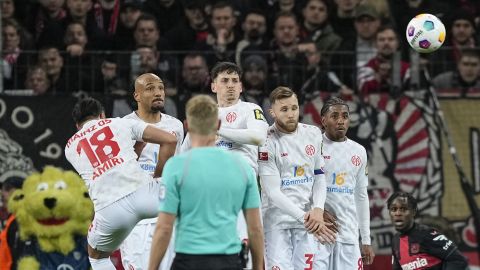 Mainz's team players jump to block the ball at a free kick during the German Bundesliga soccer match between Bayer 04 Leverkusen and 1. FSV Mainz 05 at the BayArena in Leverkusen, Germany, Friday, Feb. 23, 2024. (AP Photo/Martin Meissner)