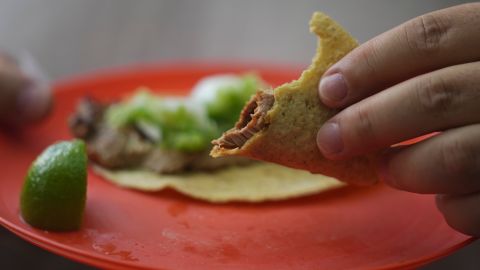 A customer holds his partially eaten taco at the Tacos El Califa de León taco stand, in Mexico City, Wednesday, May 15, 2024. Tacos El Califa de León is the first ever taco stand to receive a Michelin star from the French dining guide. (AP Photo/Fernando Llano)