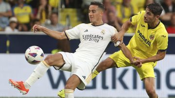 Real Madrid's Lucas Vazquez, left, and Villarreal's Santi Comesana challenge for the ball during the Spanish La Liga soccer match between Villareal and Real Madrid at Estadio De La Ceramica in Villareal, Spain, Sunday, May 19, 2024. (AP Photo/Alberto Saiz)