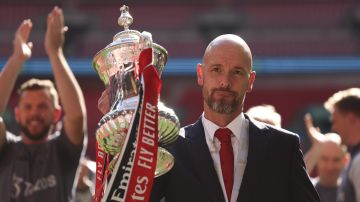 FILE - Manchester United's head coach Erik ten Hag celebrates with the trophy after winning the English FA Cup final soccer match between Manchester City and Manchester United at Wembley Stadium in London, on May 25, 2024. Manchester United manager Erik ten Hag has signed a contract extension through to 2026, the Premier League club said. (AP Photo/Ian Walton)
