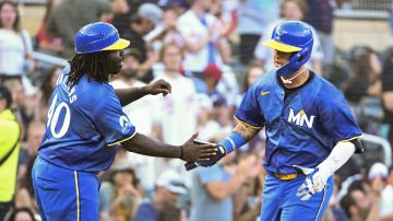 Minnesota Twins' Jose Miranda, right, celebrates with third base coach Tommy Watkins, left, after hitting a home run off Houston Astros starting pitcher Shawn Dubin during the third inning of a baseball game Friday, July 5, 2024, in Minneapolis. (AP Photo/Craig Lassig)