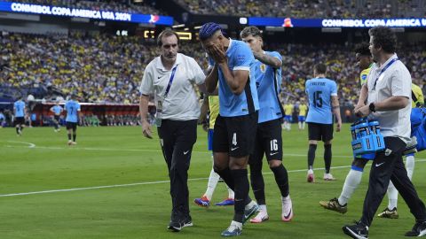 Uruguay's Ronald Araujo (4) leaves the pitch after being injured during a Copa America quarterfinal soccer match against Brazil in Las Vegas, Saturday, July 6, 2024. (AP Photo/Godofredo A. Vásquez)