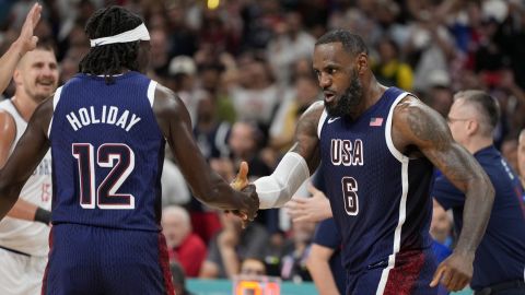 LeBron James, right, of the United States, celebrates with Jrue Holiday, of the United States, after scoring in a men's basketball game against Serbia at the 2024 Summer Olympics, Sunday, July 28, 2024, in Villeneuve-d'Ascq, France. (AP Photo/Michael Conroy)