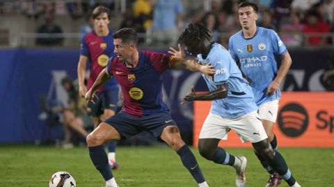 Barcelona forward Robert Lewandowski, left, gets control of the ball against Manchester City defender Luke Mbete during the second half of a Soccer Champions Tour match Tuesday, July 30, 2024, in Orlando, Fla. (AP Photo/John Raoux)