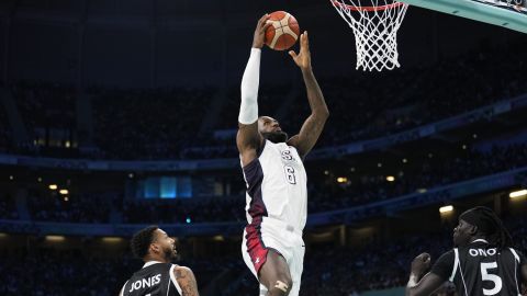 LeBron James, of the United States, gets a basket on a dunk over Carlik Jones (4) and Nuni Omot, of South Sudan, in a men's basketball game at the 2024 Summer Olympics, Wednesday, July 31, 2024, in Villeneuve-d'Ascq, France. (AP Photo/Mark J. Terrill)