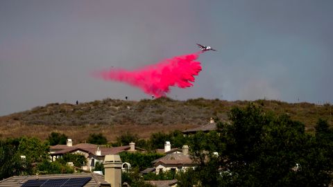 A plane drops retardant on a hillside near homes during the Sharp Fire in Simi Valley, Calif., Wednesday, July 3, 2024. (AP Photo/Eric Thayer)