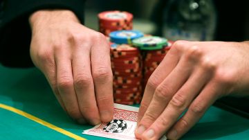 A player checks his hand during a game of Texas Hold 'em at the poker room in Caesar's Palace, Wednesday, Feb. 27, 2013, in Las Vegas. Poker has never been a big moneymaker like slot machines or roulette. In Sin City, epicenter of the poker craze, at least eight rooms have folded in the past two years. The trend is also playing out in Mississippi riverboats, Indian casinos and gambling halls near big cities from California to Florida. (AP Photo/Julie Jacobson)