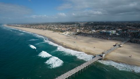 This aerial photo shows a reopened beach in Huntington Beach, Calif., Monday, Oct. 11, 2021. Huntington Beach reopened its shoreline this morning after water testing results came back with non-detectable amounts of oil associated toxins in ocean water, city officials and California State Parks announced. (AP Photo/Ringo H.W. Chiu)