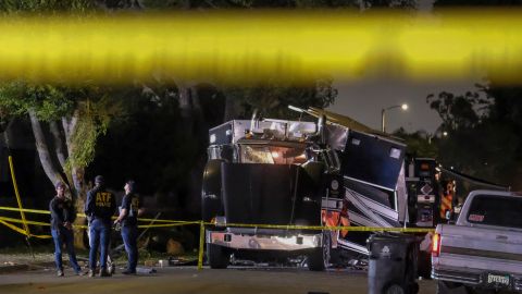 FILE - In this June 30, 2021 file photo ATF investigators are seen next to the remains of an armored Los Angeles Police Department tractor-trailer after fireworks exploded. Los Angeles bomb technicians grossly miscalculated the weight of homemade fireworks last month when they detonated them in a containment chamber, causing a catastrophic explosion that injured 17 people and rocked a neighborhood, the police chief said Monday, July 19, 2021. (AP Photo/Ringo H.W. Chiu,File)