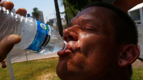 FILE - In this June 19, 2017 file photo Steve Smith takes a drink of water as he tries to keep hydrated and stay cool as temperatures climb to near-record highs, in Phoenix. Phoenix officials are launching a new safety campaign for Arizona's brutal summer season, calling on people in one of the hottest major cities in the United States to protect themselves from extreme heat that can be deadly as temperatures regularly creep into triple digits. (AP Photo/Ross D. Franklin, File)